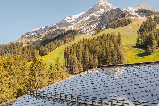 CertainTeed SunStyle solar shingle on a rooftop with a mountain view in the background